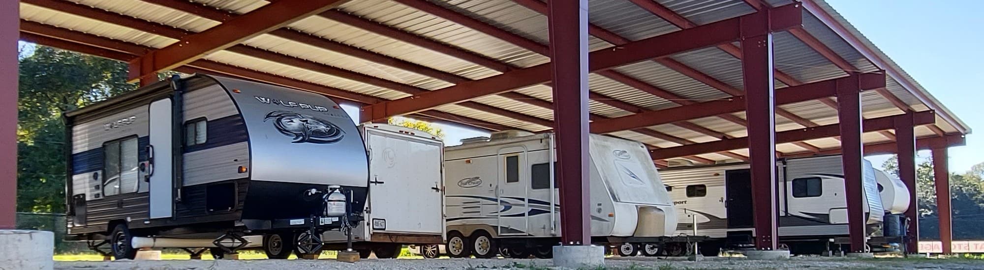 Travel trailers parked under the covered RV storage canopy